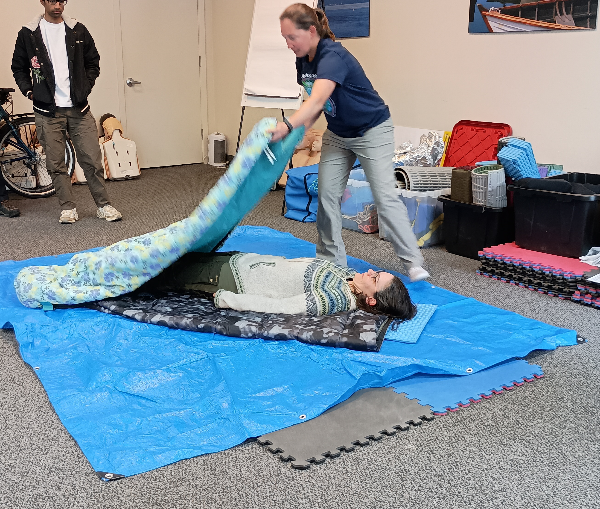 Practicing a hypothermia wrap on a volunteer at CPR Seattle