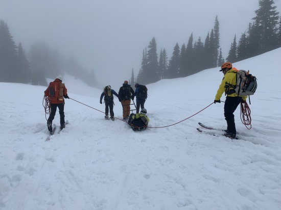 Hypothermic skier being sledded out by NPS and MRA rescuers on a training exercise